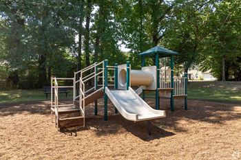 A playground with a slide and a wooden structure.
